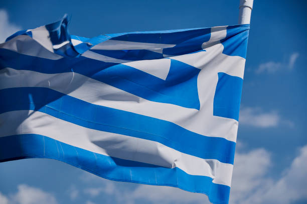 istock Greek flag against blue sky 1287567692