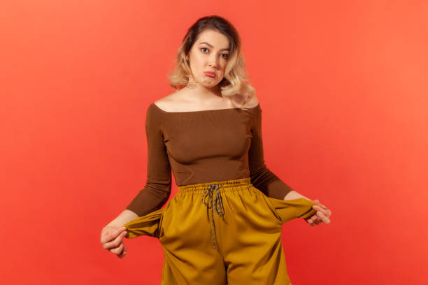 istock Girl showing empty pockets, no money 1287568705
