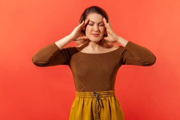 istock Young woman clasp head and feeling headache 1287568710