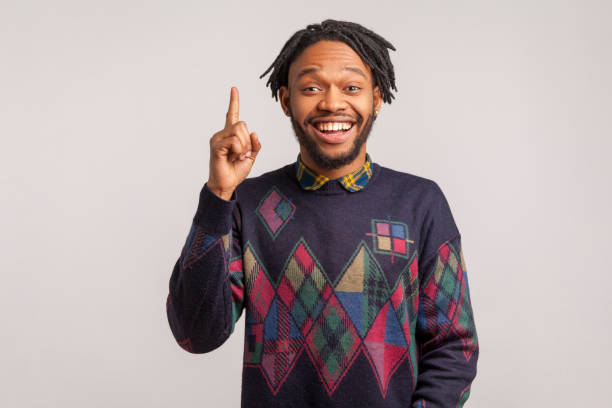 extremely happy african guy with dreadlocks in stylish sweatshirt pointing finger up with toothy smile on face, clever smart man has idea, start up - finger raised imagens e fotografias de stock