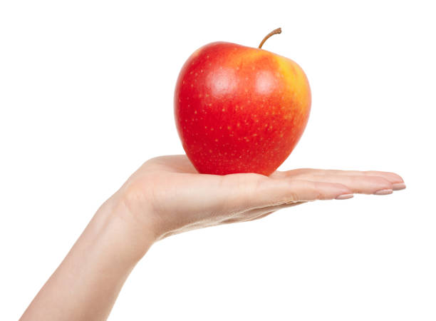 istock Hand with fresh red apple isolated on white background. 1287569627