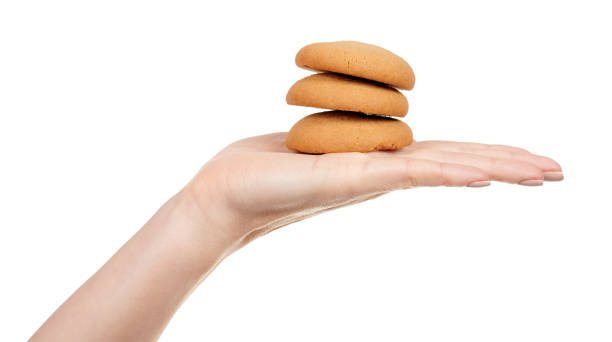 istock Hand with home made cookie isolated on white background. 1287569848