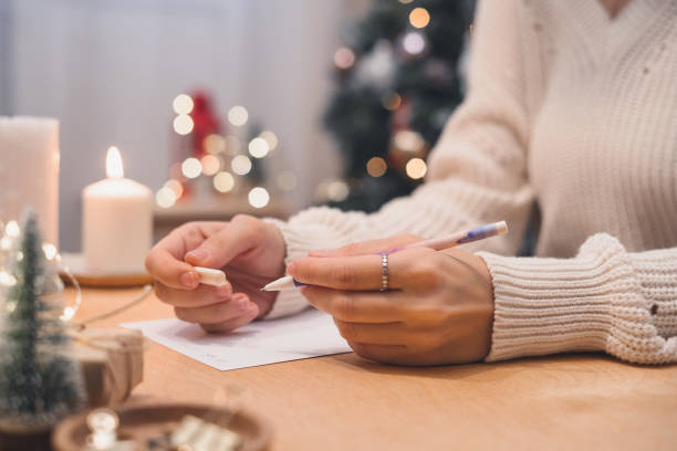 istock Woman hands with pen writing christmas wish list, goals. 1287569876