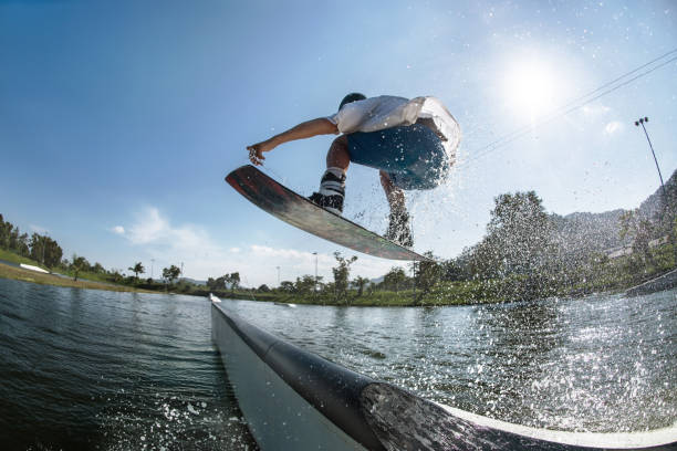 wakeboarder skacze na rampie w wake park - wakeboarding waterskiing water sport stunt zdjęcia i obrazy z banku zdjęć