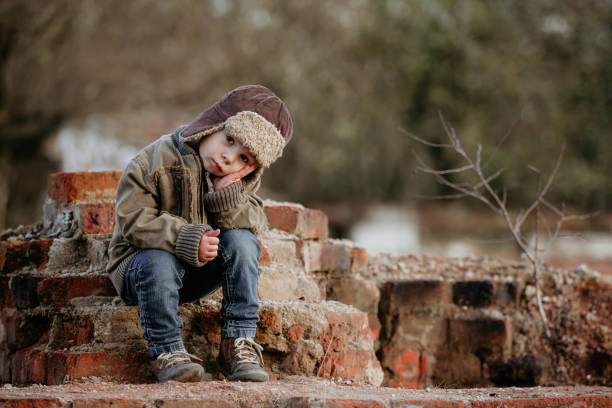 słodkie dziecko, pozowanie w ruinie domu z cegły, siedząc na tarczy okna, jesień - child graffiti grunge city zdjęcia i obrazy z banku zdjęć