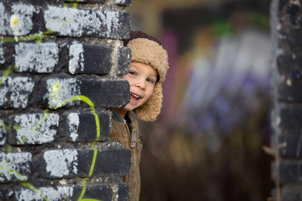 Cute little boy whit skateboard standing outdoors