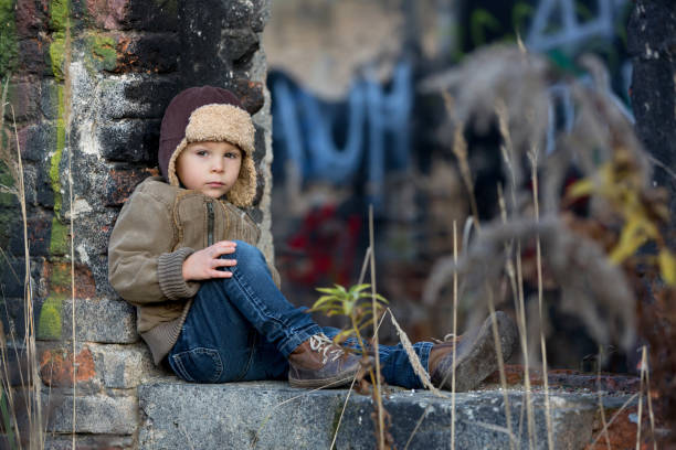 słodkie dziecko, pozowanie w ruinie domu z cegły, siedząc na tarczy okna, jesień - child graffiti grunge city zdjęcia i obrazy z banku zdjęć