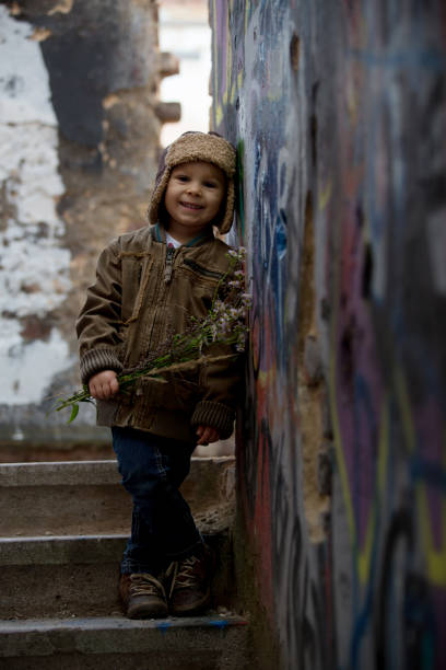 istock Cute child, posing in a ruin brick house, sitting on a window shield, autumn 1287570961