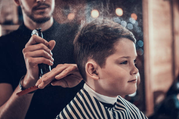istock Boy in barbershop while he is sprayed with water 1287571200