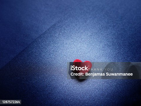 istock The word Thank You and red heart on glittering dark blue paper background. 1287572264