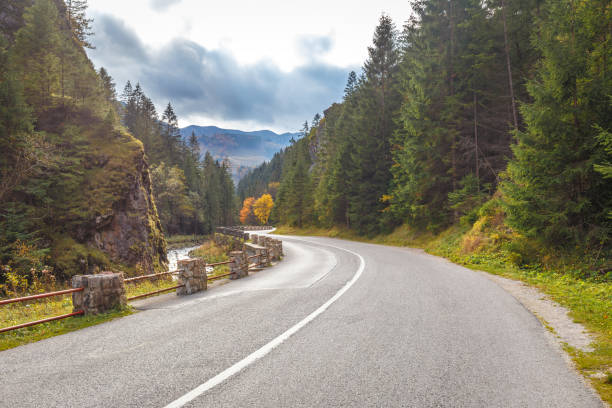 istock Road through a rocky gorge in a mountain valley at autumn. 1287574768