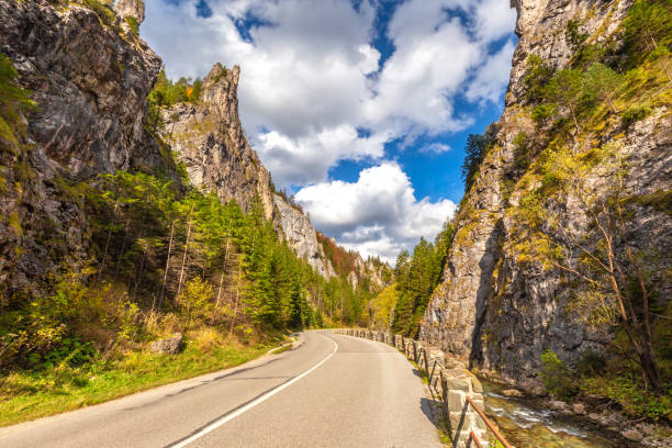 istock Road through a rocky gorge in a mountain valley at autumn. 1287574775