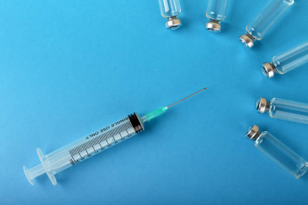 istock syringe and vial on blue background 1287575164
