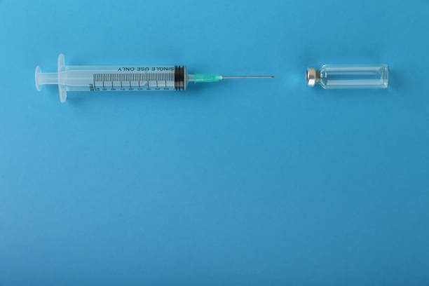 istock syringe and vial on blue background 1287575169