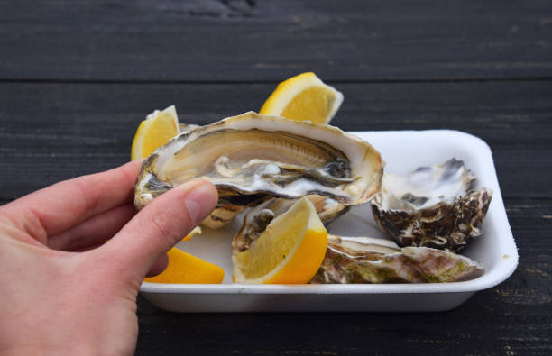 istock Woman eating fresh open oysters with lemon 1287575412