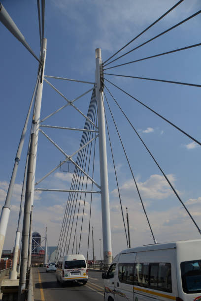 taxi driving over bridge Johannesburg, South Africa - November 02, 2020: street view of nelson Mandela bridge as white taxis are driving over midday Braamfontein johannesburg photos stock pictures, royalty-free photos & images