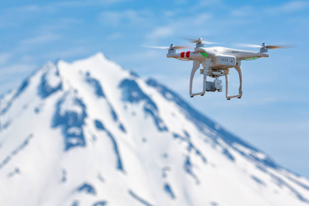 Quadcopter flying on background volcanic peak, aerial videography world around from bird's eye view stock photo