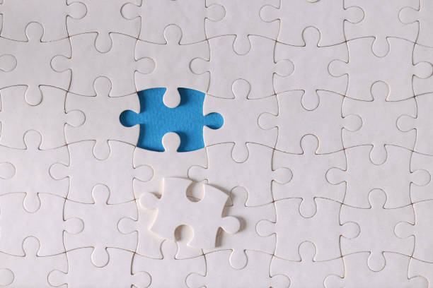 istock White puzzle pieces without one piece are on table closeup 1287579387