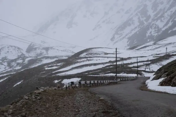 Dangerous road in the mountains. High Mountain Pass. Bad weather.