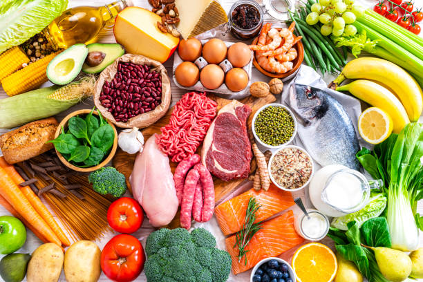 fondos alimentarios: mesa llena de gran variedad de alimentos disparados desde arriba - carbohidrato fotos fotografías e imágenes de stock