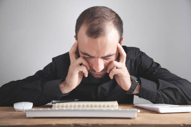 istock Caucasian thinking man sitting in office. 1287580934