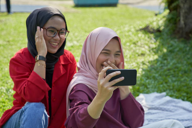 istock Two cute young women taking selfie in park 1287582916
