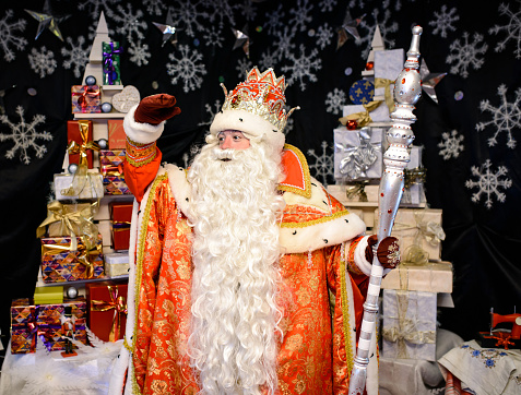 Santa Claus with a big staff hurries to the children for Christmas. House decoration. New year holiday.