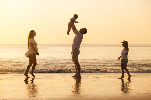 istock Family with two daughters are playing on sea beach 1287584573