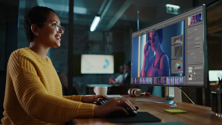 Young Hispanic Designer Working on a Desktop Computer in Creative Office Environment. Beautiful Diverse Latin Female is Editing a Fashion Photograph with Model in a Digital Graphics Editing Software.