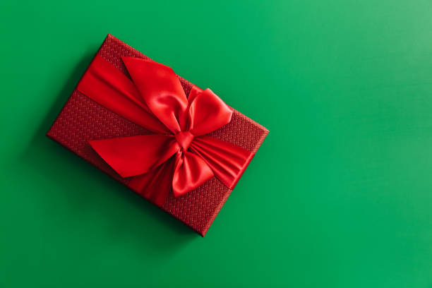 istock Red gift boxes on green background. Christmas card. Flat lay. Top view with space for text. 1287586235