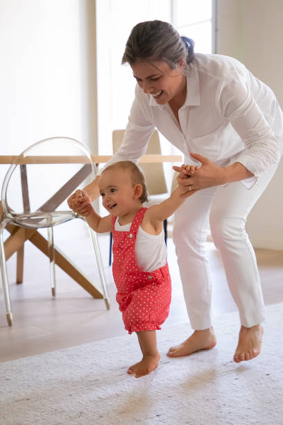 istock Happy mother helping cute baby doing first step 1287587123