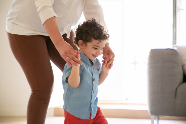 istock Funny mix-raced boy learning, walking with help of mother 1287587545