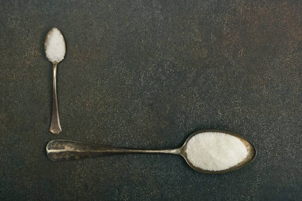 istock Two spoons of sugar and salt on table 1287588762