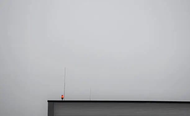 Photo of lightning conductors and red parking lights need to be installed on the roofs of tall buildings and industrial halls due to collisions with airplanes and helicopters in fog and at night. near airport