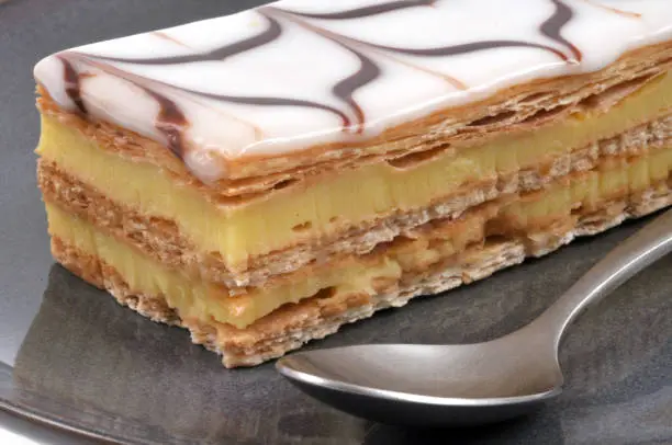 Millefeuille in a plate with a spoon in close-up