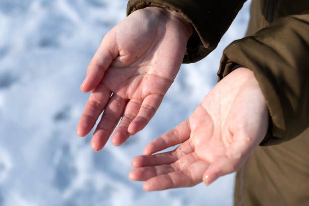 istock Woman is warming up her hands on sun after playing snowballs. 1287592217