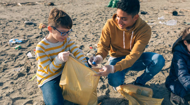 istock Young volunteers cleaning the beach 1287593508