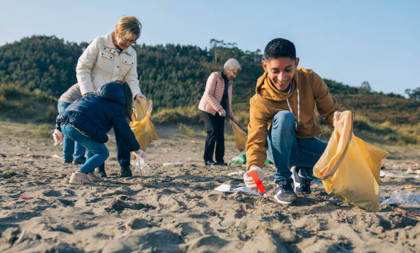 istock Young man cleaning the beach 1287593512