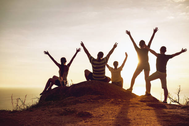 istock Happy tourists with raised arms at sunset 1287593605