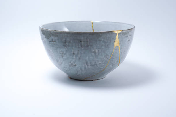 istock Kintsugi broken Japanese grey bowl repaired with gold. 1287596983