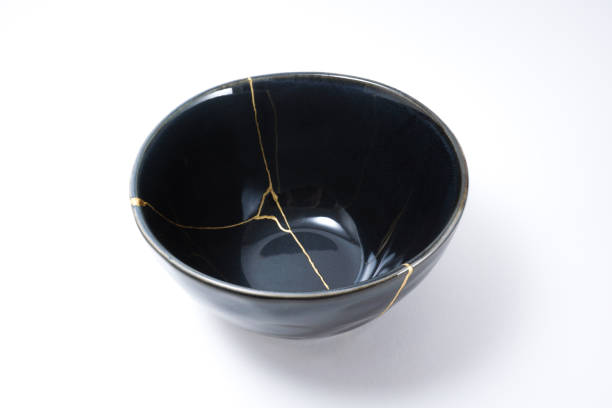 Kintsugi black bowl repaired with gold. stock photo