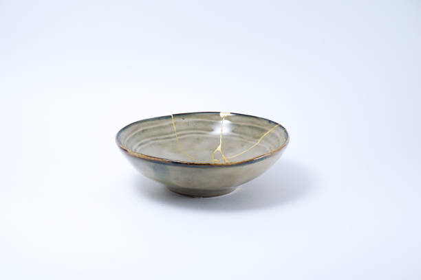 istock Kintsugi beige bowl repaired with gold. 1287597087