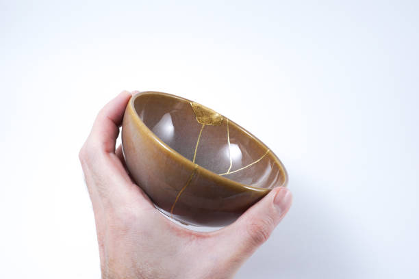 istock hand holding a Kintsugi repaired with gold. 1287597327
