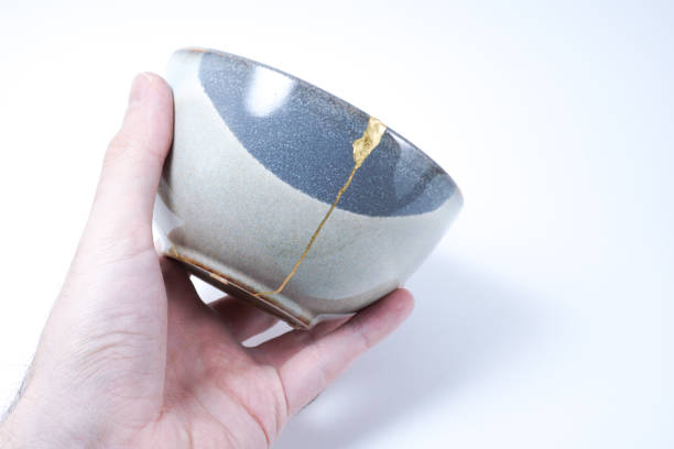 istock Kintsugi broken Japanese grey bowl repaired with gold. 1287597381