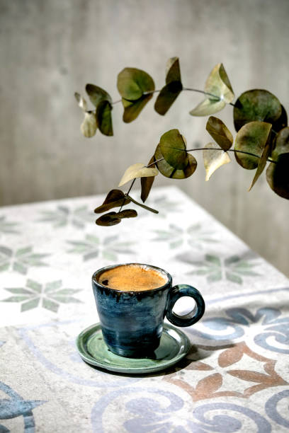 istock Cup of black coffee on ceramic table. Sun light, shadows 1287599848