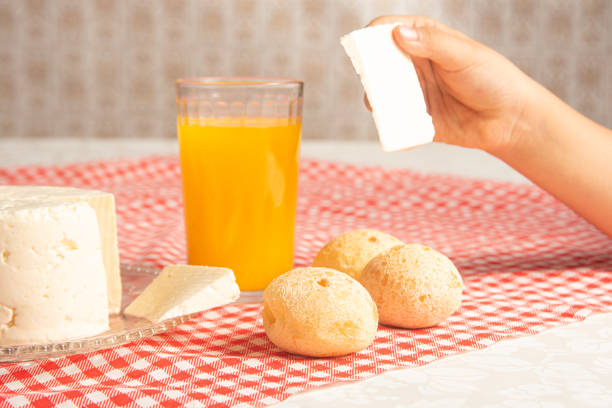 Cheese bread from Brazil. Cheese bread, Minas cheese and orange juice on a table with red and white checked tablecloth, selective focus.