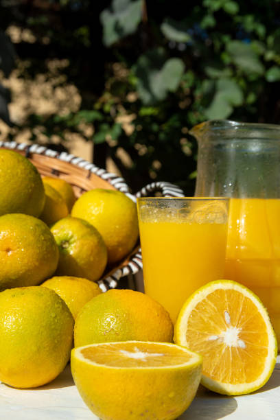 istock Oranges and orange juice on an old white table with blurred nature in the background, natural light, selective focus. 1287601447