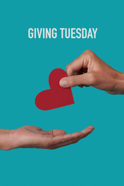 person giving a heart and text giving tuesday a person giving a red heart to another person and the text giving tuesday on a blue background giving tuesday stock pictures, royalty-free photos & images