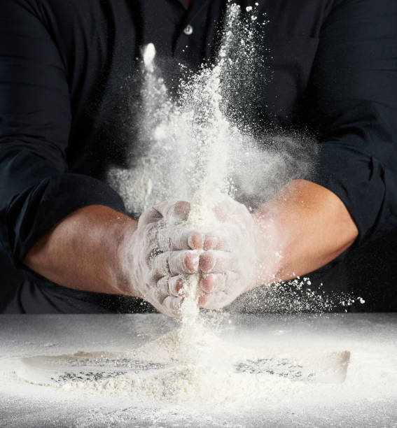 istock man in black uniform sprinkles white wheat flour in different directions 1287608426