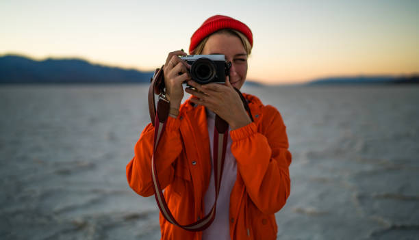 istock Smiling female photographer shooting Badwater Basin 1287608728